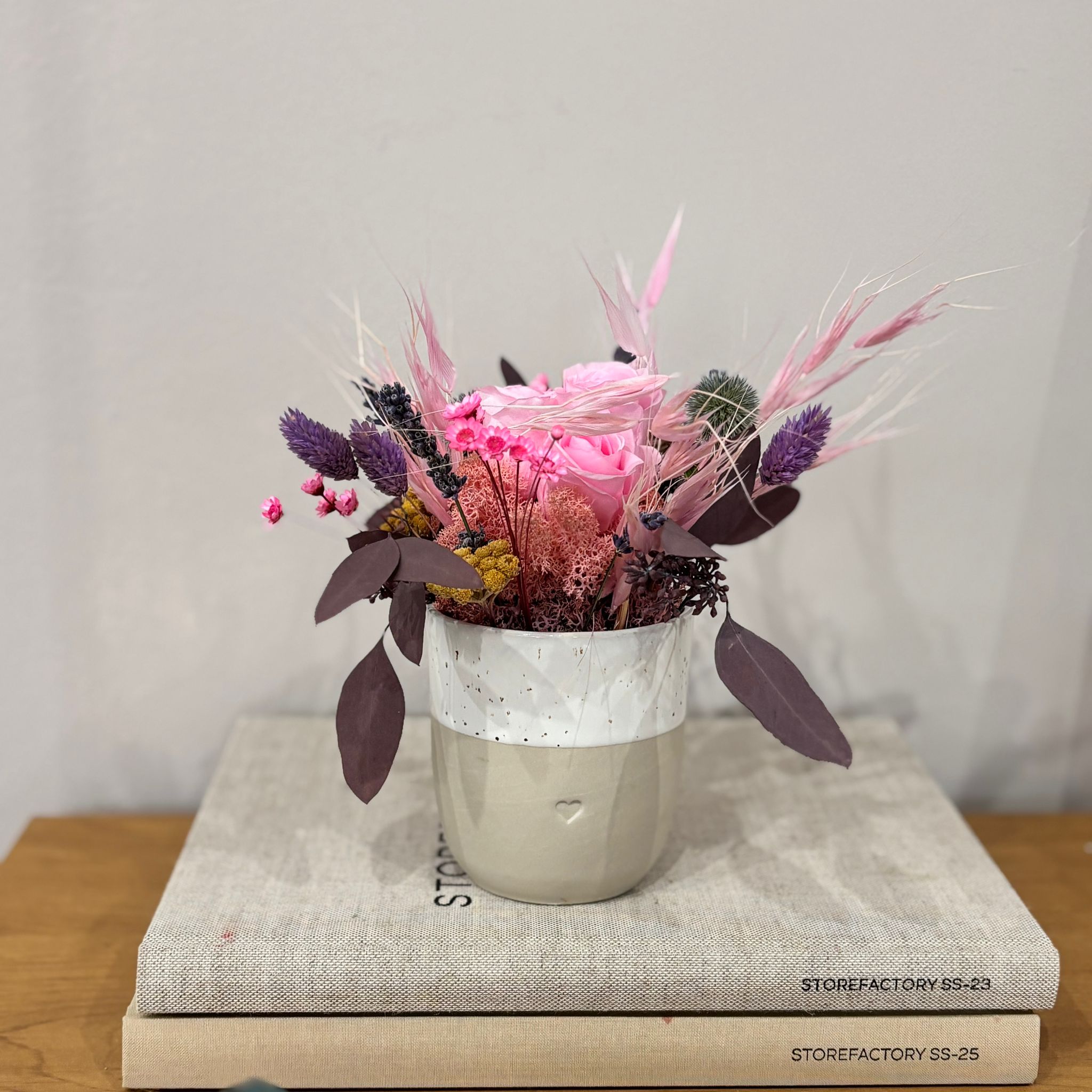 Fröhliches Gesteck mit Rose in Herz Becher