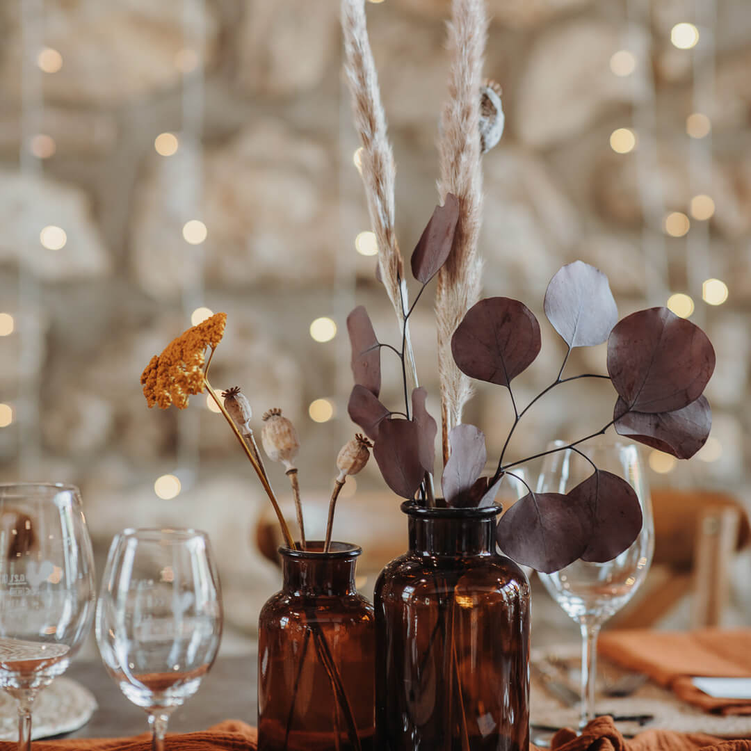 trockenblumen in vasen auf einem tisch dekoriert